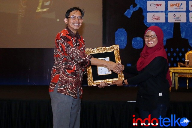 Pemberian cinderamata dari Direktur Marketing IndoTelko Group Ibu Bungsu Parlinasari kepada Ketua Asosiasi Prakarsa Indonesia Cerdas Bapak Suhono Harso Supangkat
