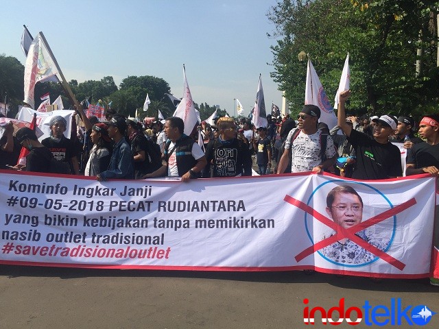 Dalam spanduk panjang yang dibawa oleh peserta tertulis dengan jelas: Kominfo Ingkar Janji, Pecat Rudiantara yang bikin kebijakan tanpa memikirkan nasib outlet tradisional.
